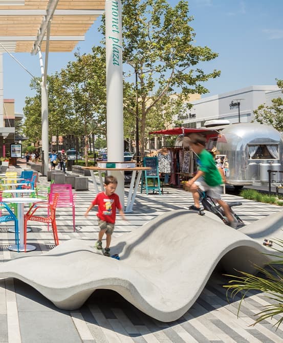 Shopping district outdoor seating, specialty bench, and airstream vendor.